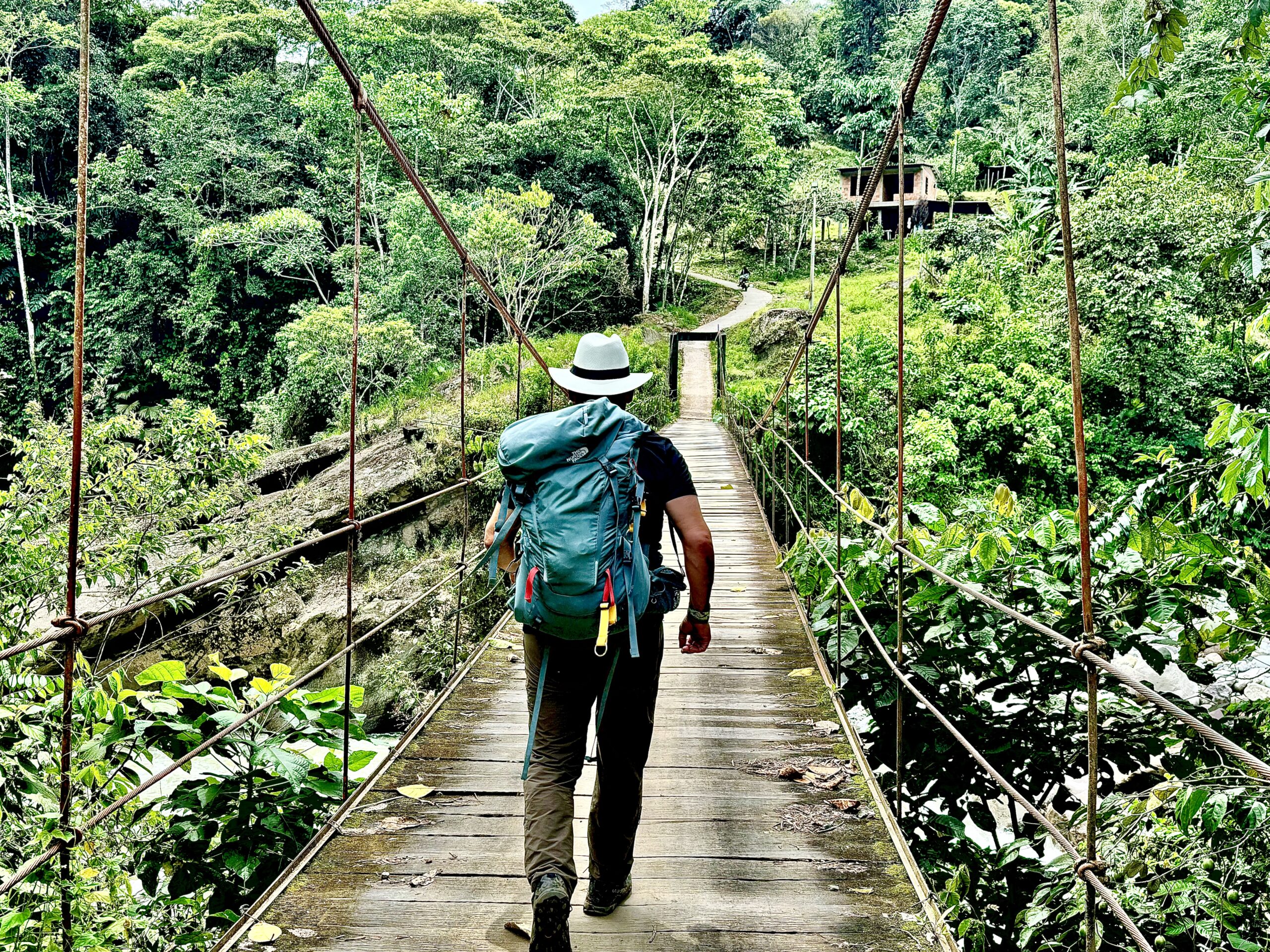 Walking across a jungle bridge with a backpack